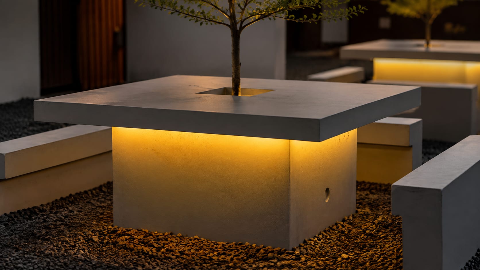 Concrete tabletop with a live sapling growing through a lit cutout at its centre